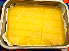 Zitronencreme auf dem Keksboden verteilen